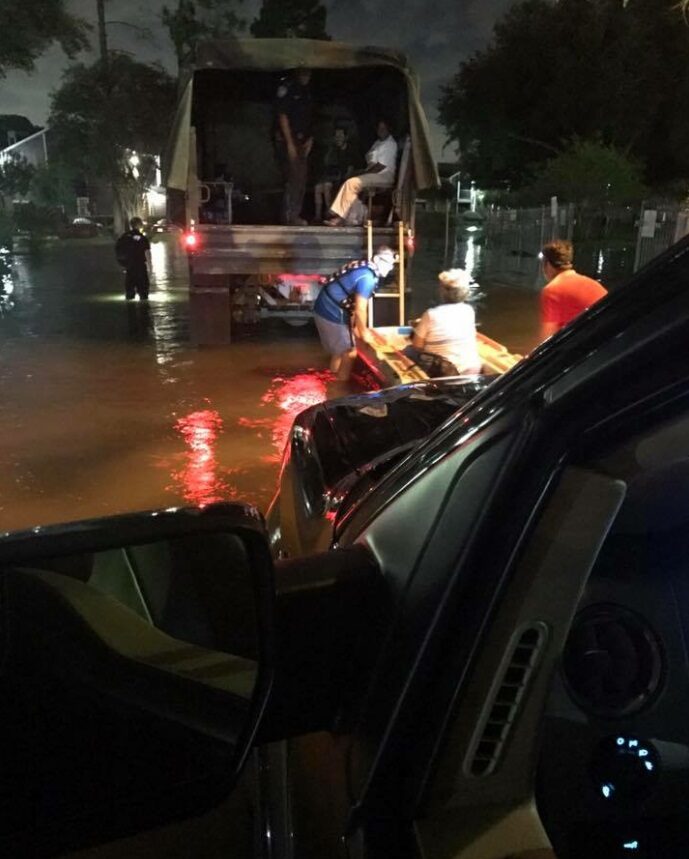 Ryan Nichols wading through floodwater on a search-and-rescue operation