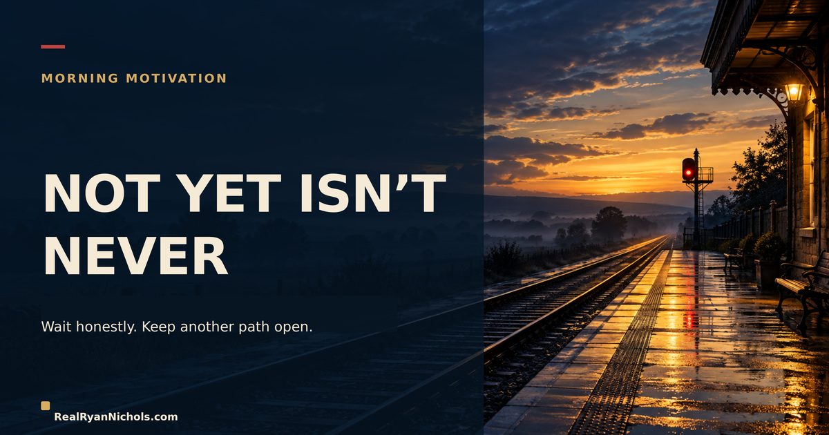 An empty train platform at dawn with one signal still glowing