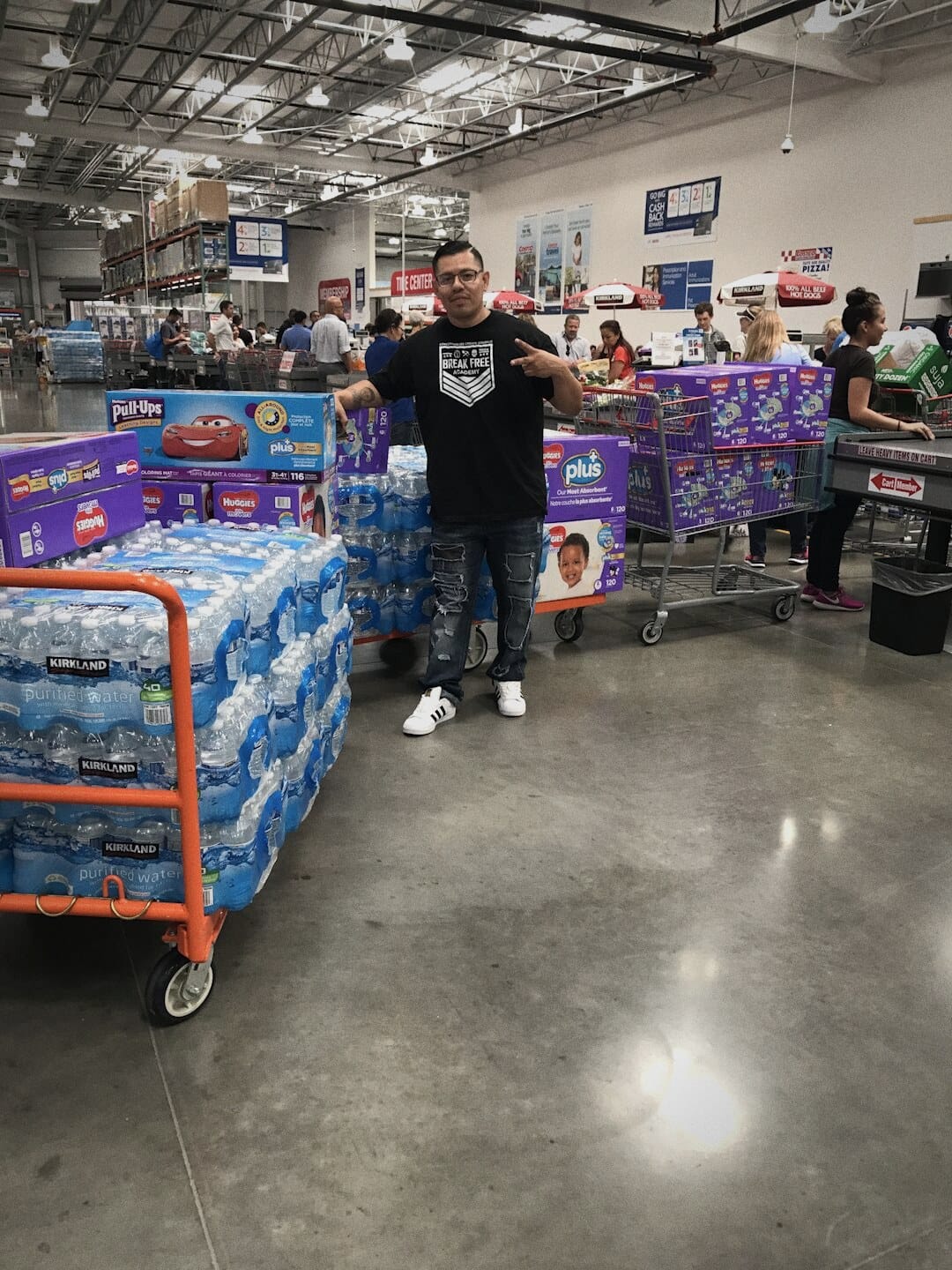 Jose, who worked with Ryan Nichols raising money and buying supplies for Hurricane Harvey victims and first responders, beside a cart stacked with cases of water