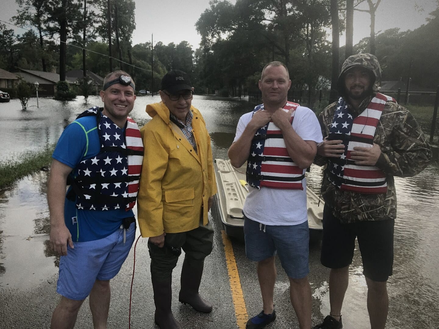 Ryan Nichols and the rescue crew in flag life vests on a flooded road